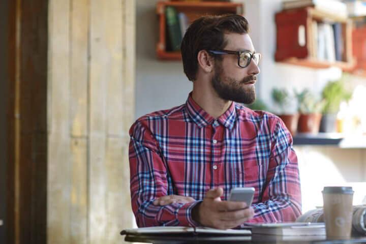 Guy daydreaming with smart phone