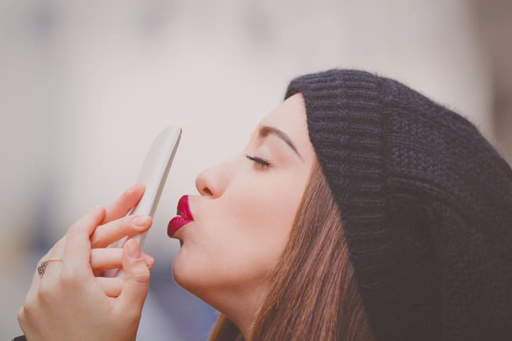 young woman kissing phone