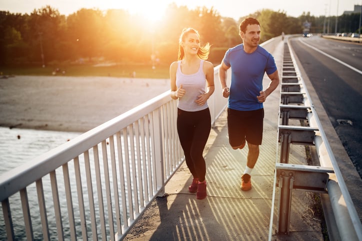 Active couple jogging outdoors during sunset