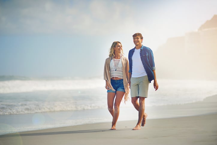 Full length shot of a young couple walking on the beach