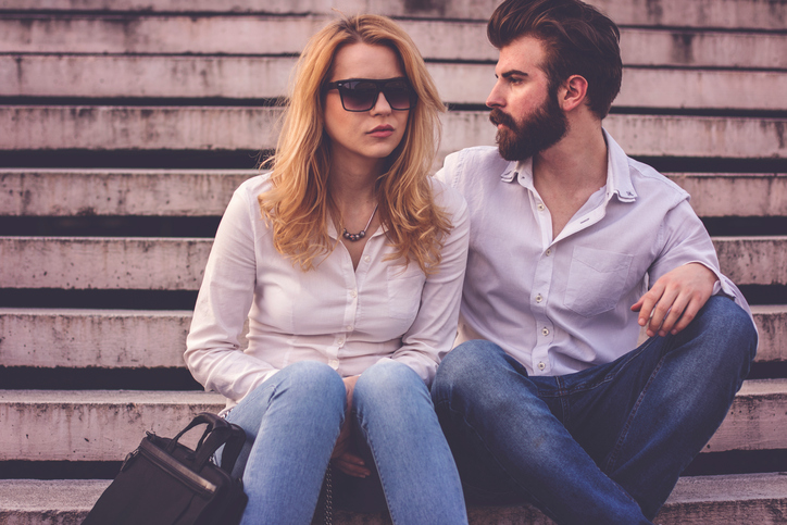Beautiful business couple sitting on stairs and discuss about job