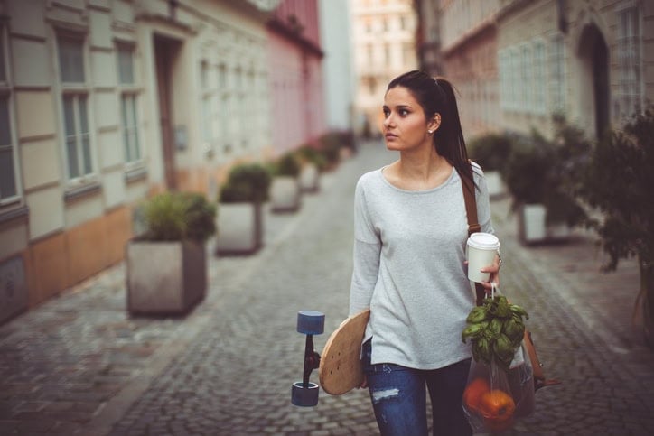 Portrait of a skater girl hitting home after a grocery shopping