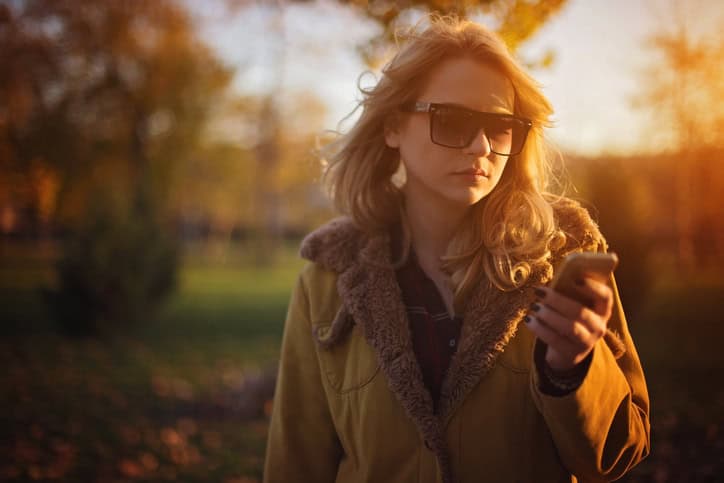 Woman sending text message on beautiful sunny day