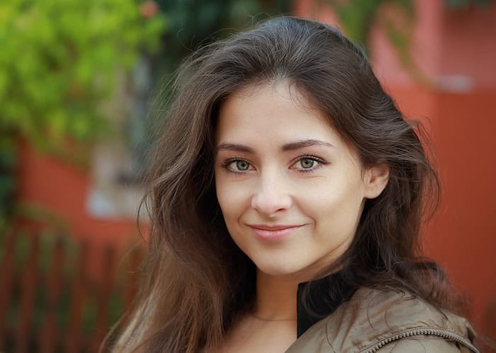 Cute woman with green eyes looking happy outdoors background