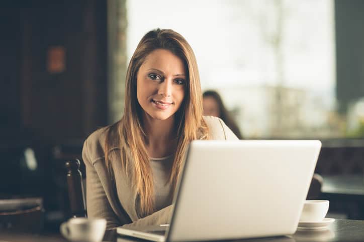 Beautiful attractive woman at the cafe with a laptop having a coffee break