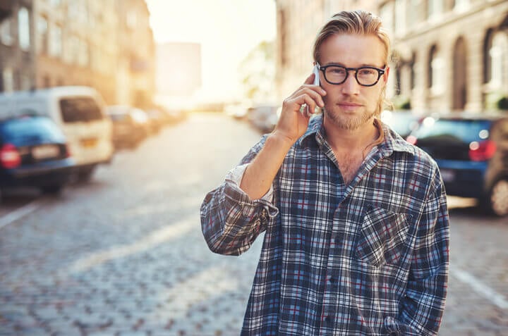 closeup portrait of young man talking on his cellphone in the city