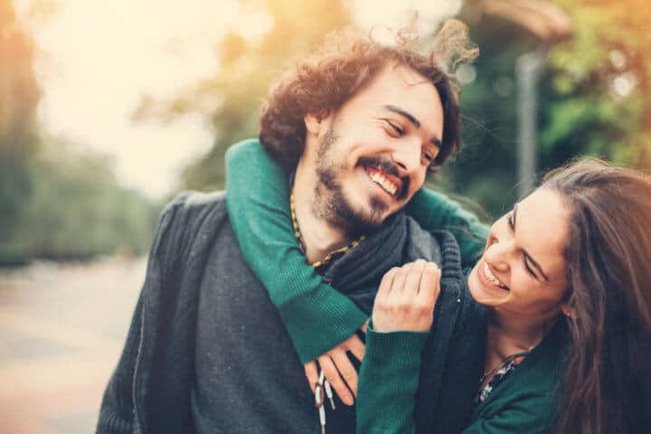Portrait of happy couple smiling outdoors.