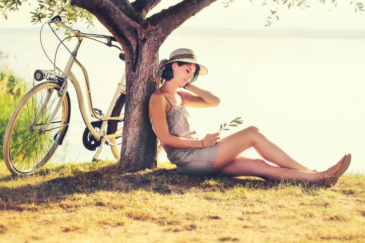 Beautiful dormant woman in love waiting under an olive's tree