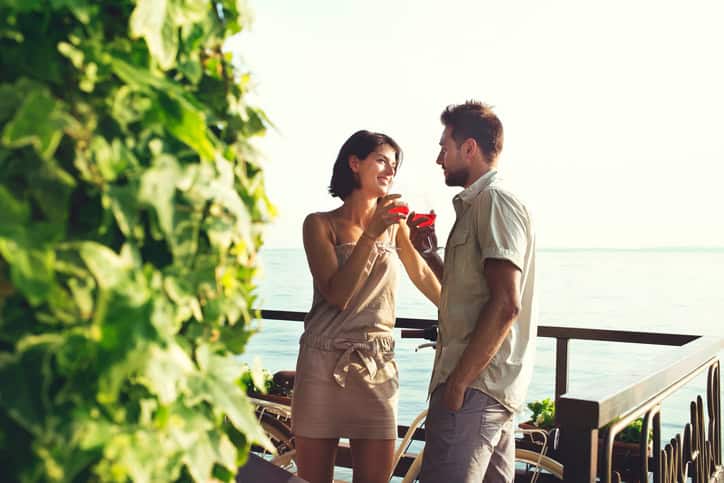 couple in love having spritz time with lake view in summer