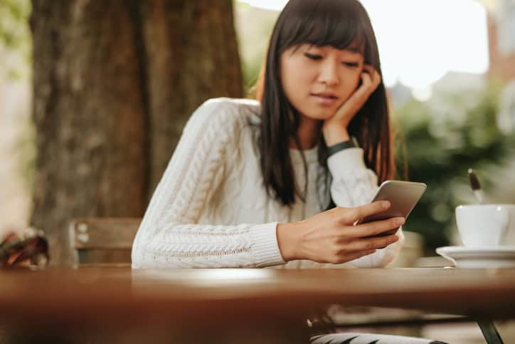 young woman texting outdoors serious