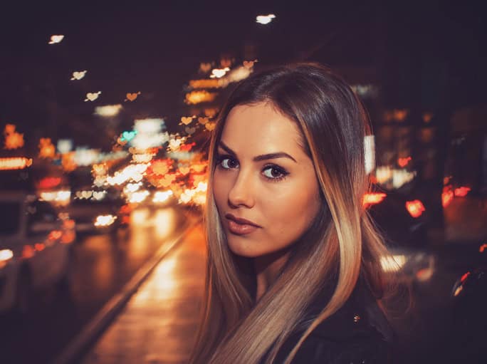 Girl walking in city at night.