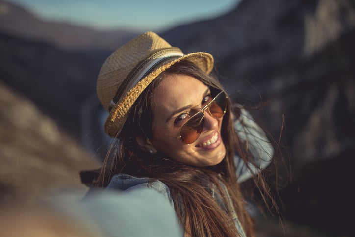 Young hipster girl taking selfie on the top of the mountain