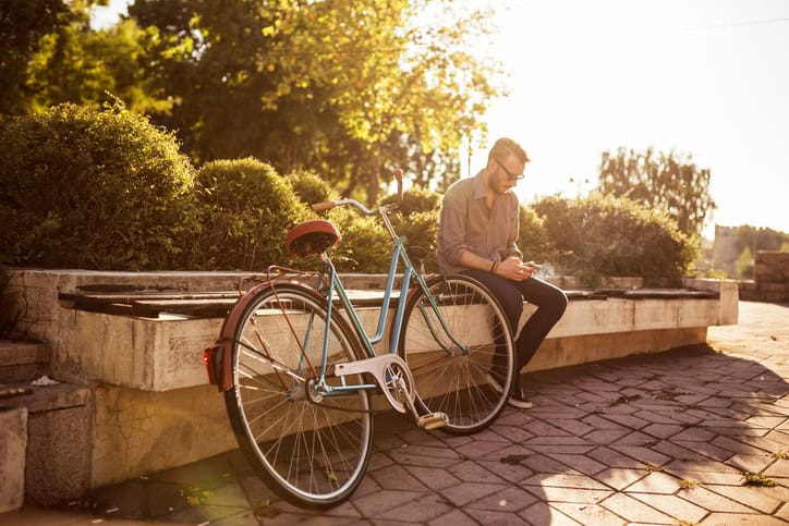 Hipster man taking a break from riding a bicycle in a park