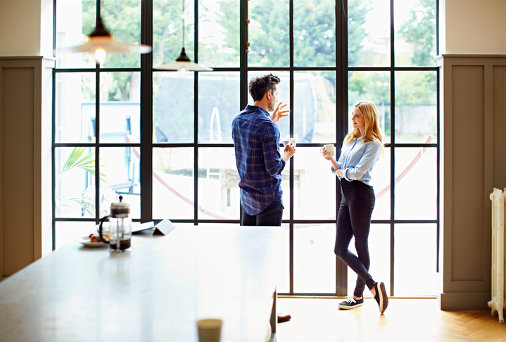 Shot of a young couple drinking coffee together in their kitchen