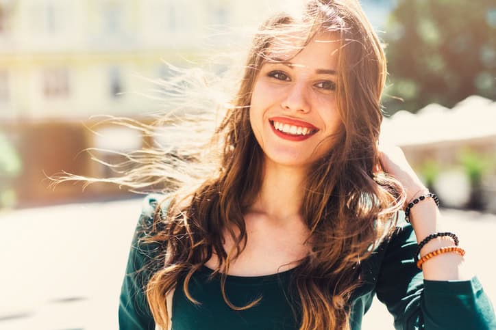 young woman happy smiling outdoors sunshine