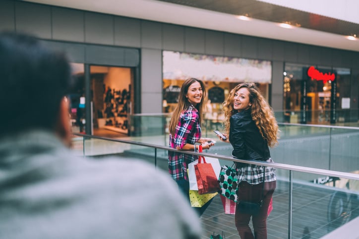 Girls smiling to a guy in the shopping mall.