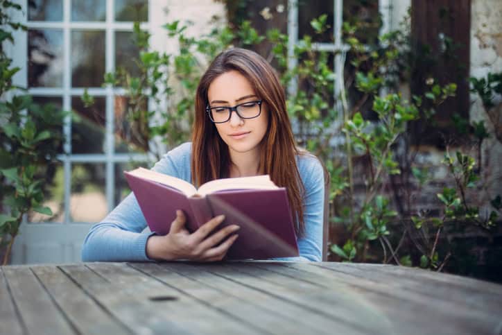 Woman reading a book at the veranda