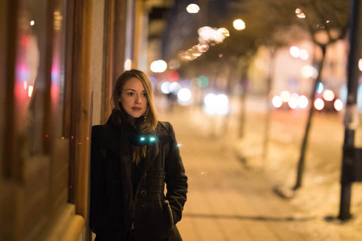 Young woman leaning on the wall in the city and waiting