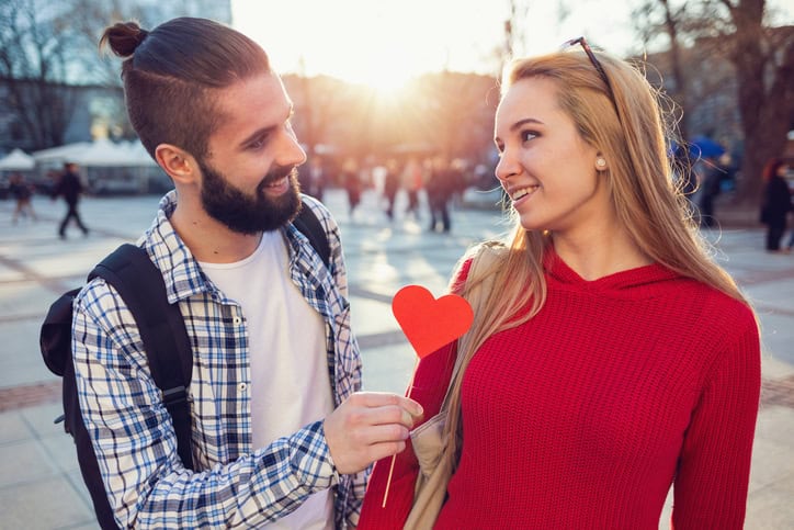 A couple in the park with heart on a stick