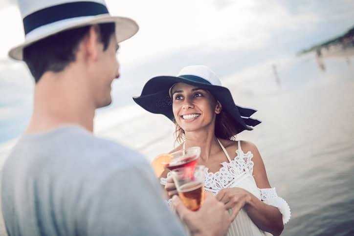 Happy Romantic Couple Drinking Cocktail by the Sea