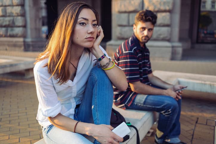 unhappy couple sitting on a wall