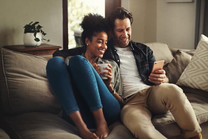 couple texting on couch