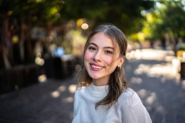 smiling woman in park sunlight