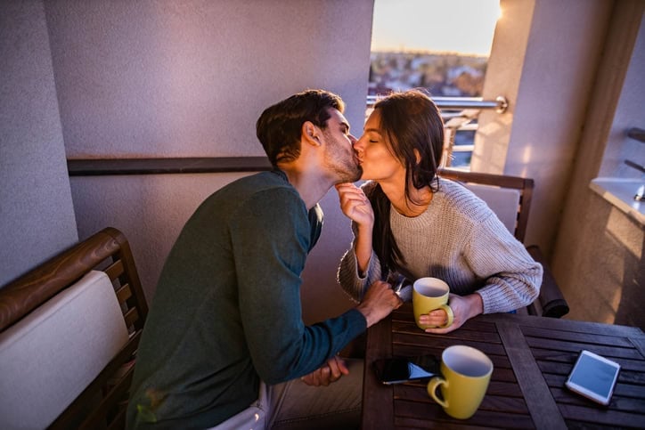 couple kissing in sunlit cafe
