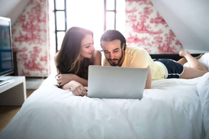 couple using the computer on the bedroom