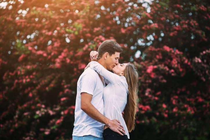 Young happy couple in love outdoors. loving man and woman on a walk in a spring blooming park