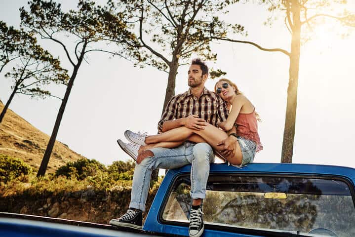 Shot of an affectionate couple pulling over to admire the scenery while on a road trip