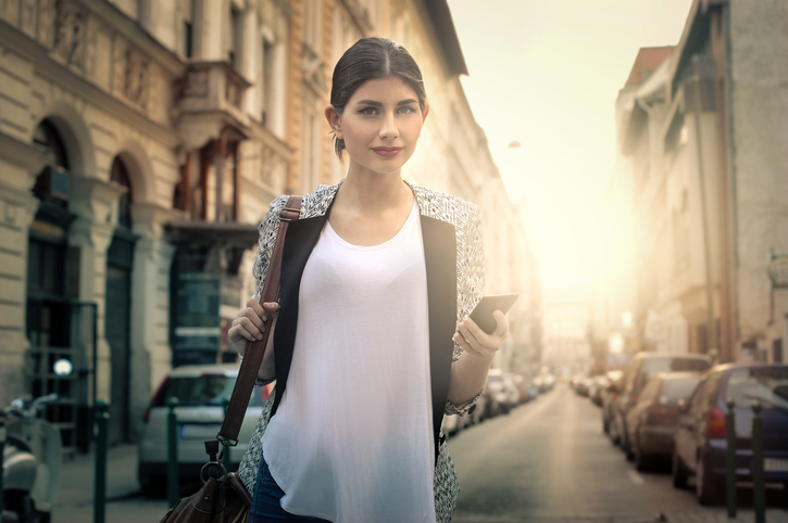 Woman using her phone on the street.