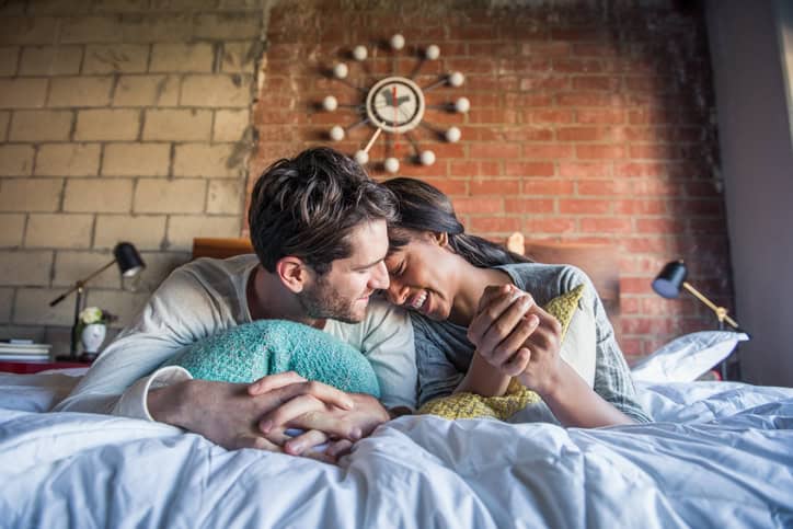 Couple spending a lazy morning in bed in their pajamas.