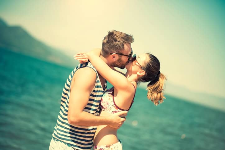 Attractive Summer Couple how Kissing at Sunset by the Sea