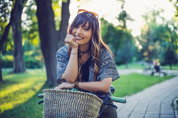 Happy woman with her bicycle in park