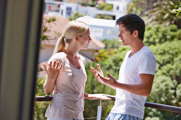 Shot of a young couple having an argument on the balcony of their home