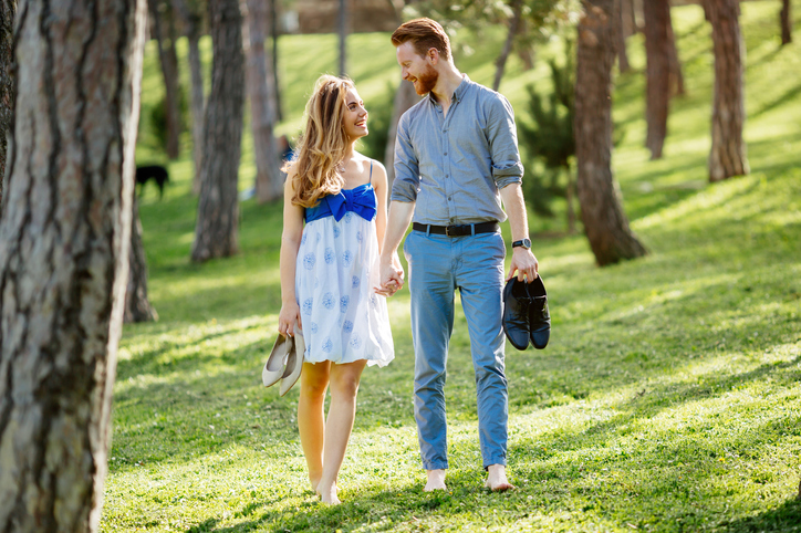 Couple enjoying romantic walk in nature barefoot