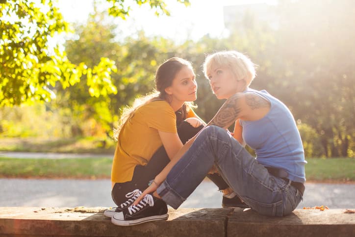 Young women sitting face to face in park