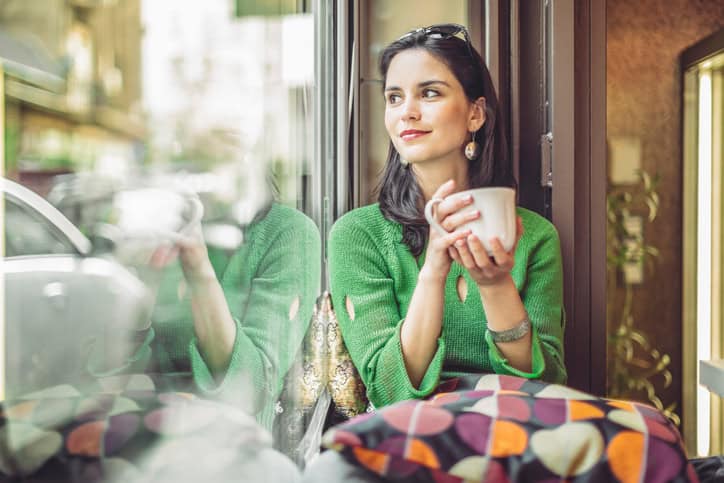Young woman enjoying a cup of coffee on a rainy day