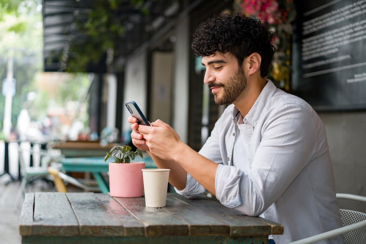 guy texting at outdoor cafe