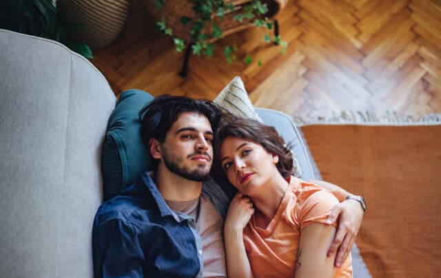 pensive couple laying on couch