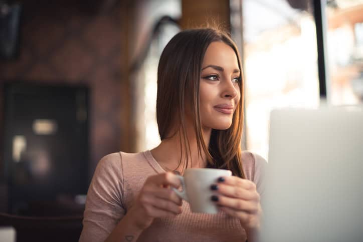 Attractive young woman taking a sip of coffee in a cafe.