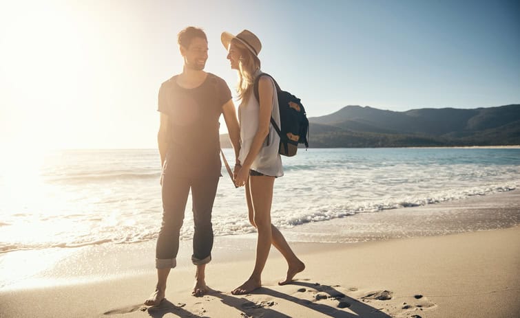 Shot of a young couple going for a stroll along the beach