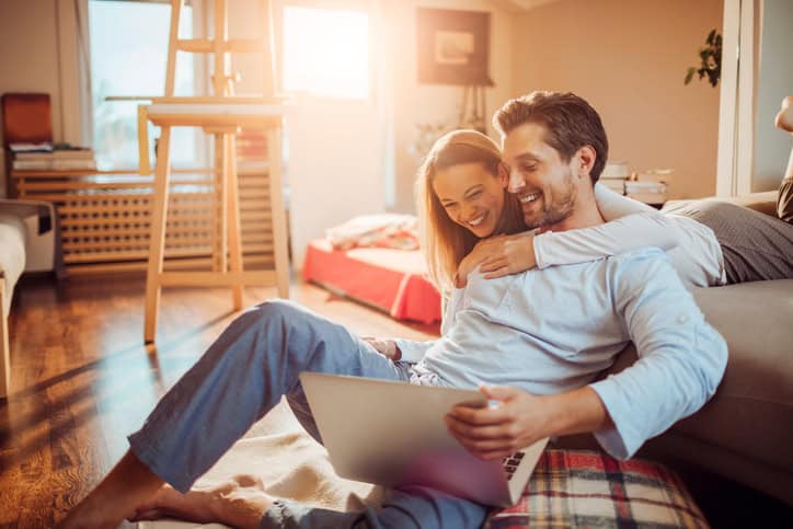 Close up of a happy young couple using laptop at home