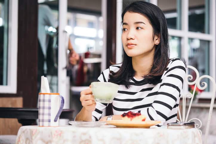 Attractive asian woman drinking coffee in a cafe
