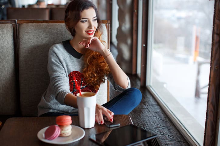 A red-haired woman with a Cup of coffee in the cafe