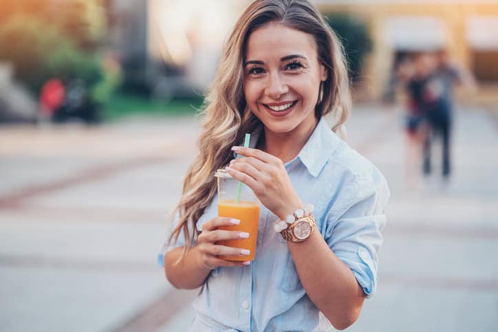 Woman drinking fresh juice outdoors.