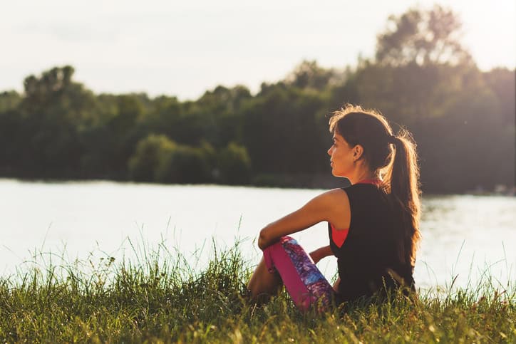 girl sat field contemplating