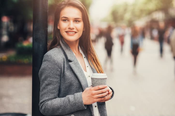 Woman drinking coffee outdoor in the city.