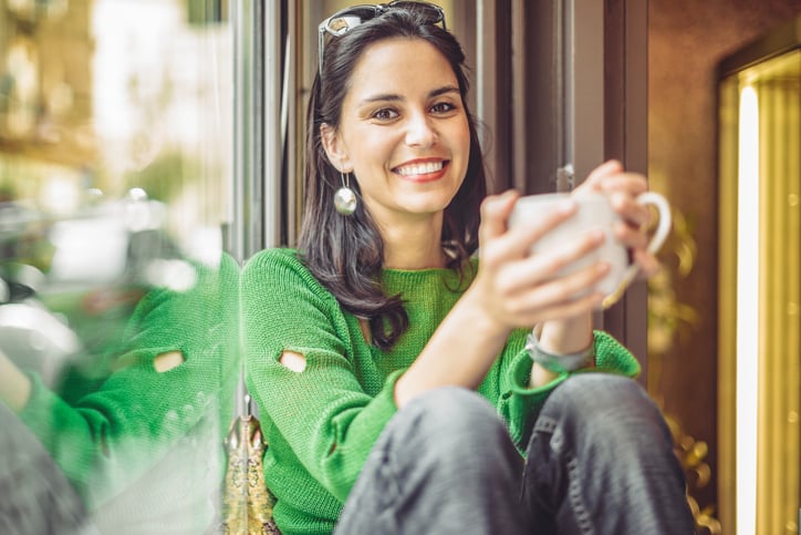 Young woman enjoying a cup of coffee on a rainy day